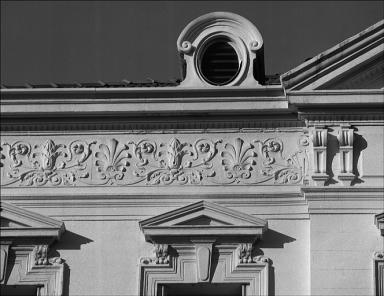 Façade antérieure. Deuxième niveau. Détail de la frise et d'une lucarne.