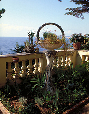 Détail : jardinière sur piédestal, en forme de panier, traitée en faux bois, située dans l'angle sud-ouest de la terrasse en terre-plein ouvrant au pied de la façade sud, depuis le nord.