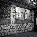 Mur de clôture. Vue partielle avec sa pergola et se grilles.