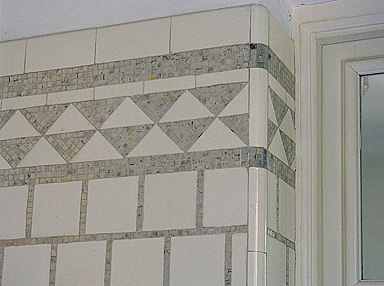 2e étage. La salle de bain nord. Détail du revêtement mural : carreaux de faîence blanche et motifs en pâte de verre argentée.