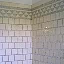 2e étage. La salle de bain nord. Détail du revêtement mural : carreaux de faîence blanche et motifs en pâte de verre argentée.