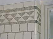 2e étage. La salle de bain nord. Détail du revêtement mural : carreaux de faîence blanche et motifs en pâte de verre argentée.