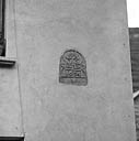Parcelle 407. Cette plaque se trouvait autrefois sur l'un des piédroits du portail qui fermait la cour. Inscription : IHS 1634.