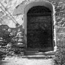 Façade antérieure sud. Porte d'entrée avec imposte en fer forgé portant l'inscription 1747/MC.