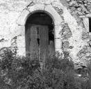 Vue de face de la porte d'entrée à arc en plein cintre chanfreiné.