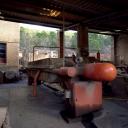 Aire de lavage de la terre. Extérieur sous appentis. "Filtre presse". Machine qui reçoit la barbotine et la conditionne en galette.