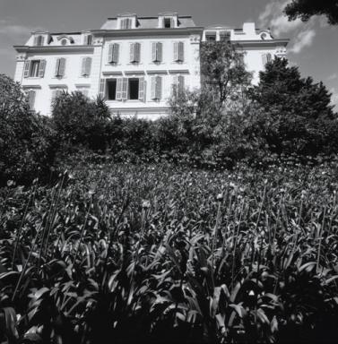 Vue d'ensemble de la façade sud avec parterre d'Agapantes au premier plan.