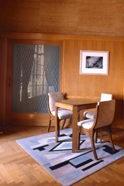 Vue partielle du'une chambre (?) avec murs lambrissés.