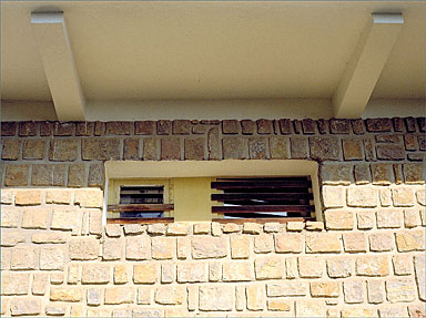 Grilles en fer-forgé et mur appareillé, au rez-de-chaussée, sur façade sud.
