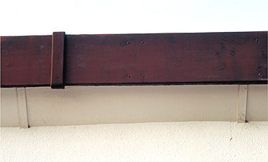 Façade sud, second niveau. Bandeau métallique d'entablement avec agrafe de fixation. Détail.