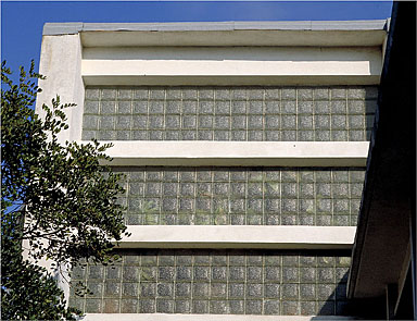 Vue de détail du mur ouest en pavés de verre sur le volume de la cage d'escalier.