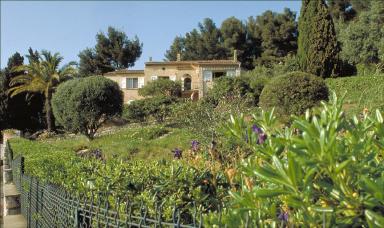 Vue d'ensemble de la façade sud avec jardin au premier plan.