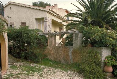 Le mur de clôture au sud-est surmonté d'une pergola et décoré de jarres en terre cuite. Vue prise depuis la terrasse sud.