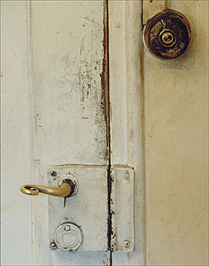 Vue de face de la poignée de la porte ouvrant sur la cuisine situées dans l'étage de soubassement.