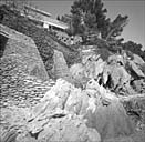 Vue d'ensemble du mur de soutènement du jardin avec la façade sud à l'arrière plan, depuis le bord de mer.