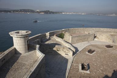 Terrasse-cour du rez-de-chaussée, restes d'absides et embrasures vers la rade, tourelle du fanal.