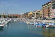Collection de pointus traditionnels regroupés dans le Bassin Lympia du port de Nice ; église Notre-Dame du port en arrière-plan à gauche.