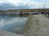 Cale de halage du port de Saint-Tropez avec la jete et la prud'homie de pche en arrire-plan.