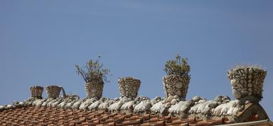 Villa. Arte du toit rythme par des pots de fleurs dcors de coquillages.