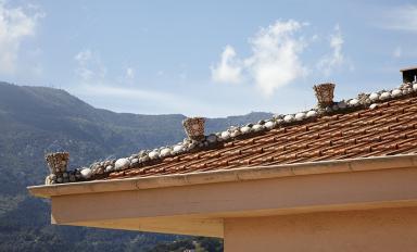 Villa. Arte du toit rythme par des pots de fleurs dcors de coquillages.