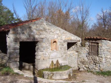 Vue de la façade principale du puits, de la fontaine et du lavoir du Boisset, Saint Julien le Montagnier.