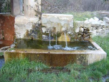 Vue du bassin en pierre de taille de la fontaine de l'Eclou, Saint Julien le Montagnier.