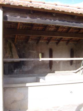 Vue des bassins, des plans de lavage et de la barre d'essorage du lavoir couvert des Bernes, Saint Julien le Montagnier.