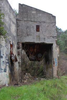 Silo de stockage accolé au mur où est inscrit le nom de l'établissement