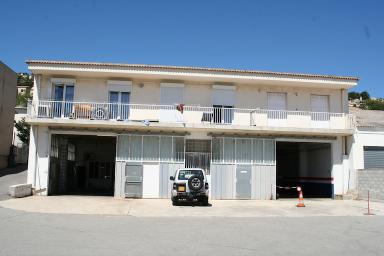 Vue de la façade arrière ouvrant sur l'espace garage (ex. usine d'agglomérés) au RdC, surmonté d'un étage de logements.