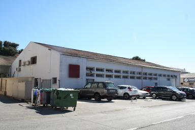 vue d'angle façade est, percée d'ouvertures dont l'entrée de l'usine et des bureaux