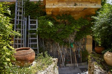 Outils de jardin poss contre la faade Ouest de la villa.