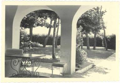 [Villa Zro  Antibes. La pice de gazon ombrage de platanes devant la loggia, vue prise depuis la loggia.] Vers 1950.