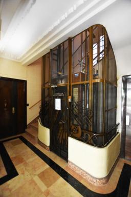 Entrée sur boulevard, cage d'escalier avec ascenseur.