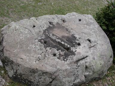 Bloc de pierre taill et perc de trous au pied de l'escalier d'accs.