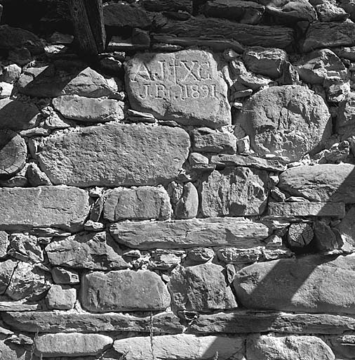 Inscription grave sur une pierre du mur-gouttereau nord.