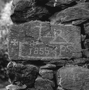 D 421 en aval des Choulires. Sur un chalet en empilage avec socle en pierre, inscription sur le chanage d'angle : 1855 PS et 18(4 ou 6)9.