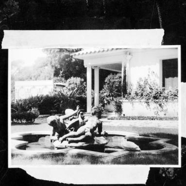 Le jardin. Bassin avec groupe sculpté devant la façade sud de la maison.