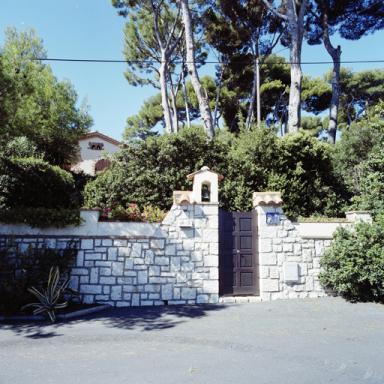 Villa le mas du Pirate. Parcelle 1979 BX 92. 49, avenue des Pins du Cap. Mur de clôture et portail du jardin. VUe prise de l'est.