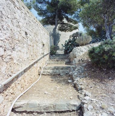 Mur de clture crnel de l'enceinte et chemin de ronde montant vers la tour.