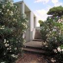 La maison. Le perron avec l'escalier montant aux terrasses de couverture. Vue prise de la cour d'entrée.