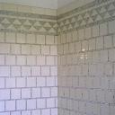 2e tage. La salle de bain nord. Dtail du revtement mural : carreaux de faence blanche et motifs en pte de verre argente.