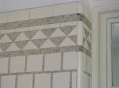 2e étage. La salle de bain nord. Détail du revêtement mural : carreaux de faîence blanche et motifs en pâte de verre argentée.