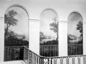 Vue de dtail du dcor peint de la cage d'escalier avec le garde-corps en ferronerie au premier plan, vers 1930.