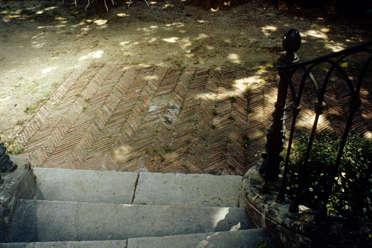 Cour avec pavement en briques en arte-de-poisson; dpart de l'escalier de la terrasse.