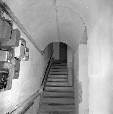 Couloir voûté en berceau et escalier en vis.