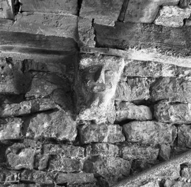 Corbeau sculpté soutenant le passage couvert.
