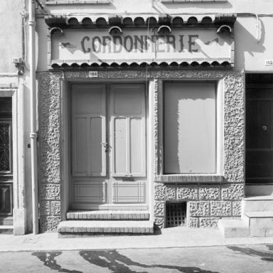 Devanture de la cordonnerie qui occupe le rez-de-chaussée.