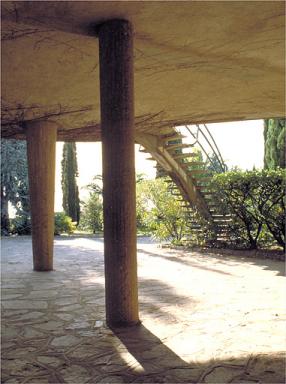 Les pilotis sous la terrasse avec l'escalier en arrière plan, depuis le nord.