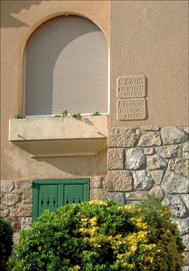 Détail, fenêtre avec jardinière en appuie et plaque d'architecte, sur façade sud depuis le portail.