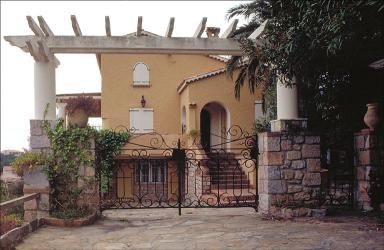 La pergola et le porche d'entrée à l'arrière plan, depuis le portail.